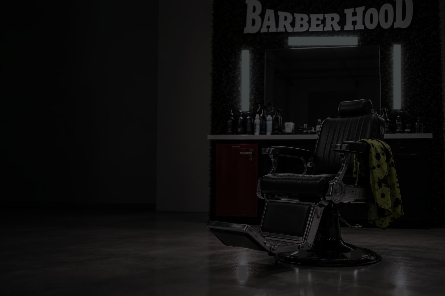 El sillón de BarberHood, vacío, en penumbra frente al espejo con los tubos apagados